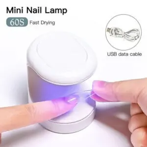 Mini lámpara LED UV de uñas 16W secando una uña postiza con luz púrpura.